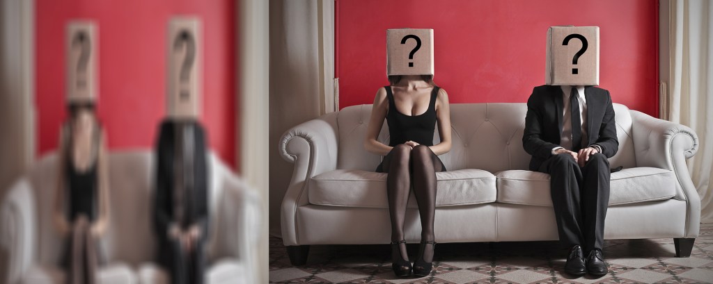 Pareja sentada en un sofa, con cajas en la cabeza. Cada caja tiene un signo de interrogación.